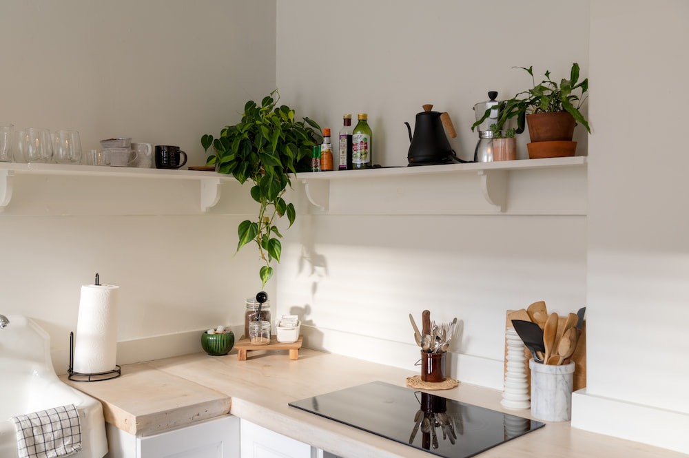 bright decluttered kitchen with utensil storage and openshelf