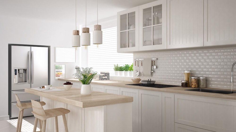 organized kitchen with white cabinets and wood counters