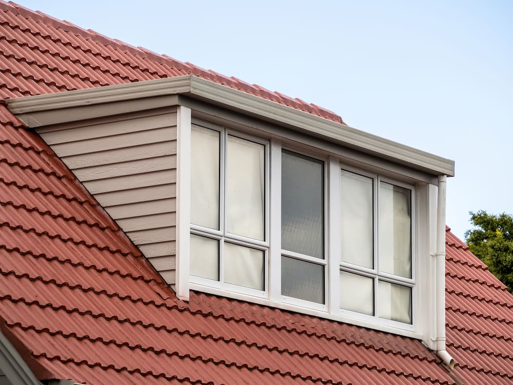 dormer on a red roof-home addition to add more square footage