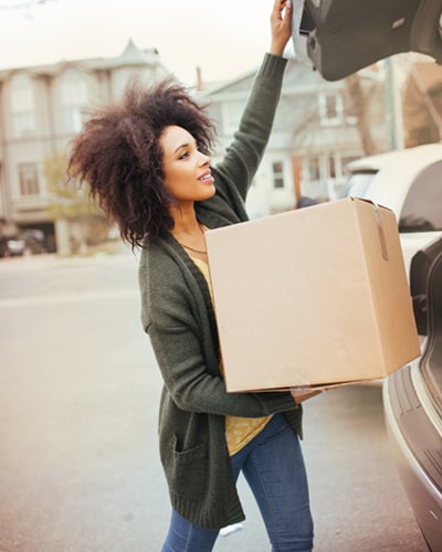 Woman unloading boxes for storage