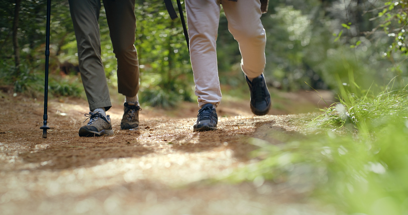 Two people's feet on a walking trail.