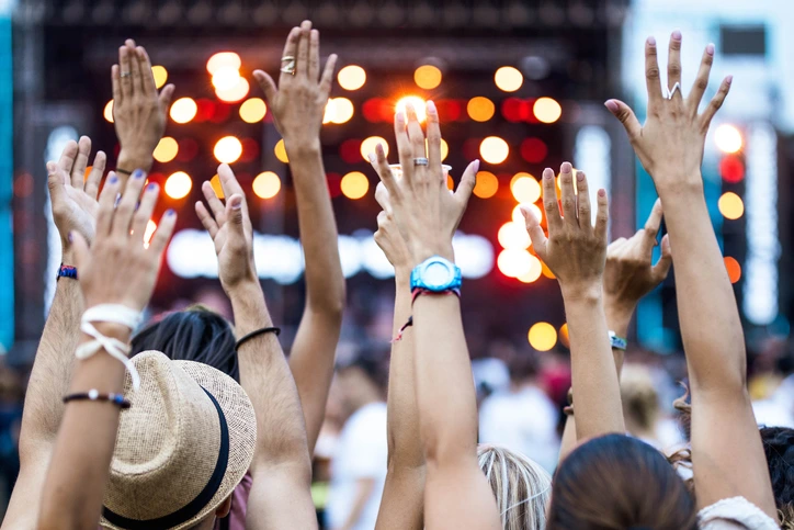 Outdoor concert hands raised at an outdoor concert