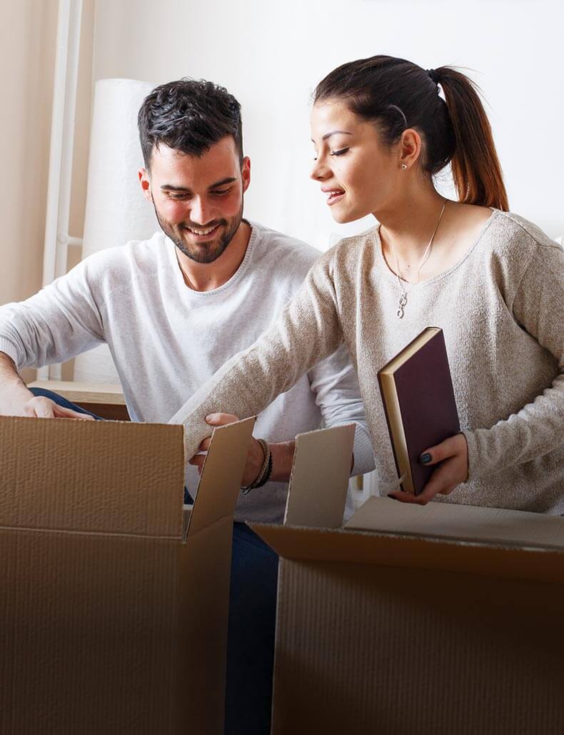 A man and a women putting objects in a box.